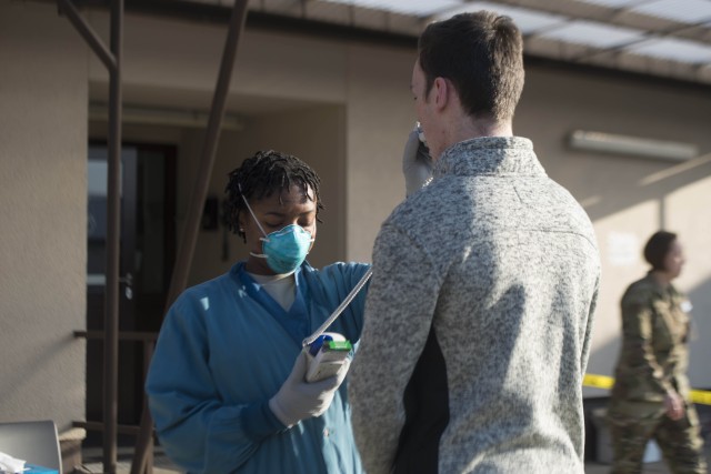 U.S. Air Force Airman 1st Class Sharmayne Campbell, 86th Medical Group aerospace medical technician, takes a patient’s temperature at the Ramstein Medical Clinic, Ramstein Air Base, Germany, March 19, 2020. To enter the clinic, each patient...