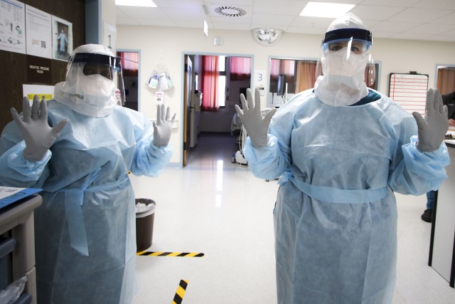 (From left) U.S. Army Lt. Col. Janet Glenn and Dorothy Hall, both critical care nurses at Landstuhl Regional Medical Center, don personnel protective equipment during COVID-19 operations at LRMC’s Intensive Care Unit, April 1. Health care personnel across LRMC are on the front lines for preventing the spread of COVID-19 as they continue providing patient care.