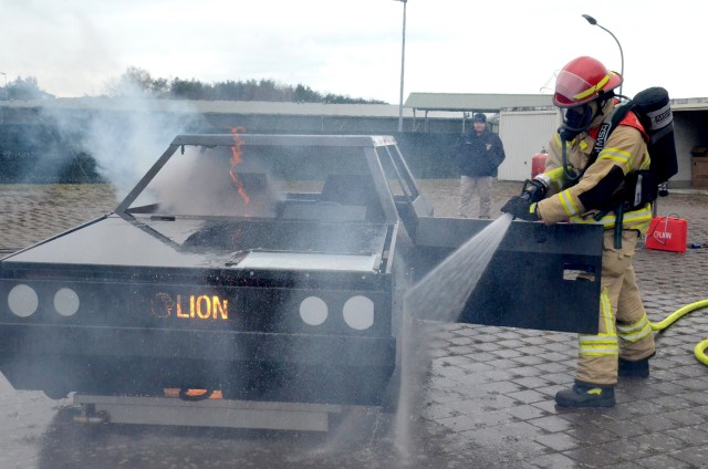 A firefighter from the U.S. Army Garrison Rheinland-Pfalz trains to put out a car fire using the garrison's new Hose Line Training Aid System. Training chiefs can switch out different training aids to simulate fires with propane tanks, barbecue...