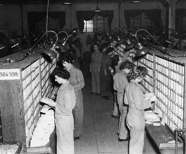 Women in the Women&#39;s Army Corps (WAC) at the U.S. Army base post office in England sort mail by military unit number, 1944. WAC was created as an auxiliary unit, the Women&#39;s Army Auxiliary Corps in 1942, and converted to full status as the...