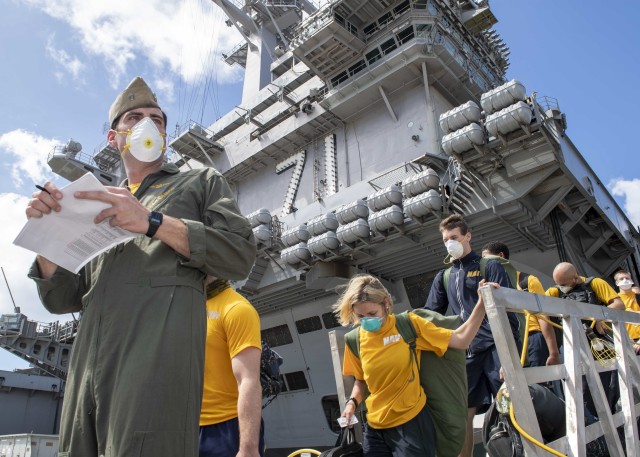 200410-N-CH038-1120 APRA, Guam (April 10, 2020) U.S. Sailors assigned to the aircraft carrier USS Theodore Roosevelt (CVN 71) depart the ship to move to off-ship berthing April 10, 2020. Upon arriving in Guam March 27, Theodore Roosevelt...