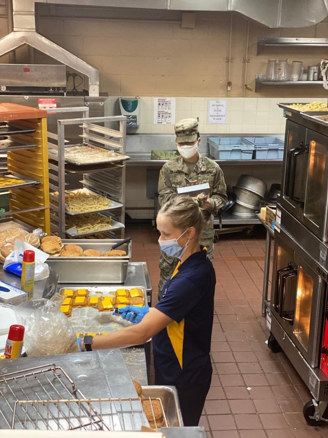 U.S. Army Spc. Regina Shillingburg, Public Health Activity-Guam veterinary food inspection specialist, is monitoring a restaurant employee preparing food at the Navy Exchange food court, Naval Base Guam, April 2020. To help mitigate the risk of...