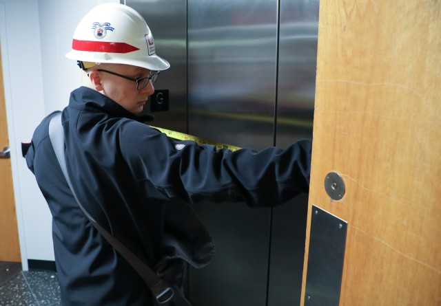 Andy Temeyer, architect, U.S. Army Corps of Engineers – Omaha District, measures the width of doors on an elevator April 6, during a site assessment of a building in Omaha, Neb., the state is considering turning into an alternate care facility...