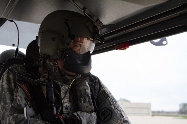 Sgt. Jason Humke, a helicopter maintainer with Company A, 1st Battalion, 376th Aviation Security and Support, Iowa Army National Guard, prepares for flight in a UH-72 Lakota helicopter before a mission in Waterloo, Iowa, on May 4, 2020. COVID-19 test kits from a Test Iowa site in Sioux City, Iowa, were transported by helicopter to the State Hygienic Laboratory in Coralville, Iowa. (U.S. Army National Guard photo by Cpl. Samantha Hircock)