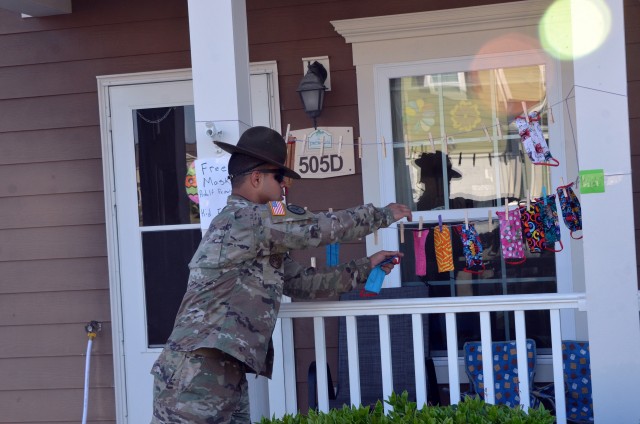 Staff Sgt. Adrian Gonzales, a drill sergeant with 1st Battalion, 61st Infantry Regiment, selects masks for his family. Staff Sgt. Chris Waggoner and Family members Rebecca, Jerry and Sarah made these masks available for the community. (Photo by...