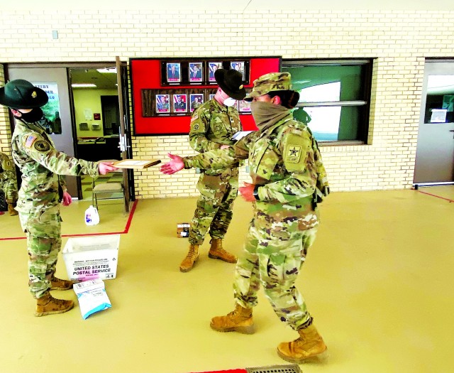 A 1st Battalion, 79th Field Artillery Drill Sergeant, left, hands a piece of mail to a Basic Combat Training Soldier while maintaining social distance and wearing a face mask. Mail call is a welcome connection to loved ones during these stressful times.
