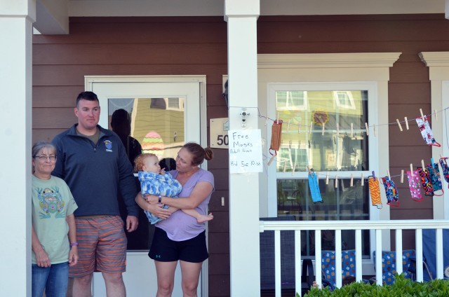 Staff Sgt. Christopher Waggoner and Family members (left) Debbie, Chloe, and Rebecca stand outside their family quarter near masks that they have made available for the community. Waggoner is a drill sergeant with 3rd Battalion, 34th Infantry...