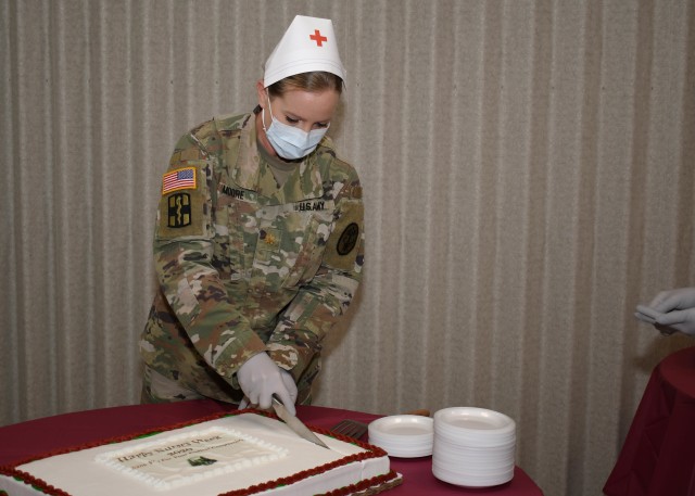 FORT DRUM, N.Y. – Maj. Betty Moore, the chief of ambulatory nursing, U.S. Army Medical Department Activity (MEDDAC), Fort Drum, N.Y., begins cutting a cake during the National Nurses Week kick-off celebration at the Guthrie Ambulatory Healthcare...