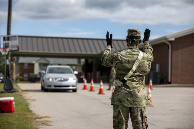 Spc. Alonzo Clark, assigned to the North Carolina National Guard’s 1-130 Attack Reconnaissance Battalion, 449th Theater Aviation Brigade, directs cars through a parking lot where his unit is helping Action Pathways Second Harvest Food Bank of Southeast North Carolina transport and hand out food in Raeford, N.C. on May 5, 2020. More than 900 NCNG Soldiers and Airmen have been activated in response to COVID-19 relief efforts to help support NC Emergency Management, N.C. Department of Health and Human Services, and their local communities. 