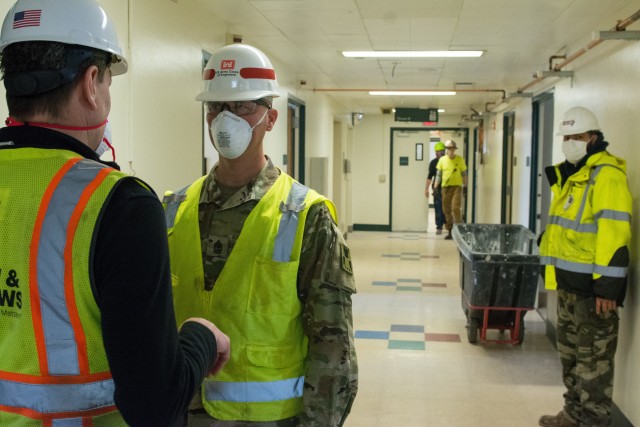 Left, a contractor provides an update to the progress of his scope of work to Sgt. Maj. John Nelson. Nelson, a U.S. Army Reserve Soldier from the 416th Theater Command supporting U.S. Army Corps of Engineers project to rehabilitate Westlake Hospital in Melrose, Ill. into an alternate care facility (ACF) during the COVID-19 pandemic, April 23, 2020 (U.S. Army photo by Sgt. 1st Class Jason Proseus/416th TEC).