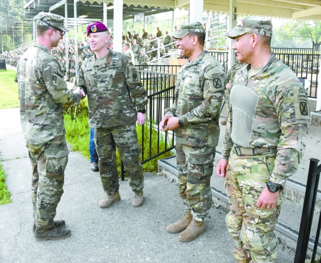 First Lt. Preston Bentley, Alpha Company, 2nd Battalion, 4th Infantry Regiment, 3rd Brigade Combat Team, 10th Mountain Division, receives a commander’s coin from Brig. Gen. Patrick D. Frank, commander, JRTC and Fort Polk, after finishing first...