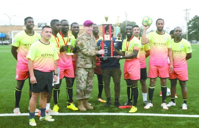 Brig. Gen. Patrick D. Frank, commander, Joint Readiness Training Center and Fort Polk, presents a trophy to members of the Fort Polk soccer team on Anvil Field, the new artificial sports and fitness surface on Fort Polk.