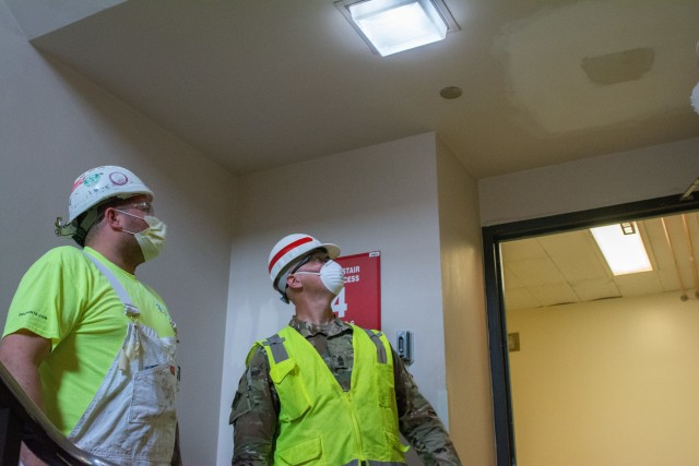 Left, a contract painter provides an update to the progress of his scope of work to Sgt. Maj. John Nelson. Nelson, a U.S. Army Reserve Soldier from the 416th Theater Command supporting U.S. Army Corps of Engineers project to rehabilitate Westlake Hospital in Melrose, Ill. into an alternate care facility (ACF) during the COVID-19 pandemic, April 23, 2020 (U.S. Army photo by Sgt. 1st Class Jason Proseus/416th TEC).