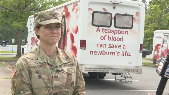 Col. Jody L. Dugai, Bayne-Jones Army Community Hospital commander, poses with a LifeShare blood-drive bus during a recent blood drive on the BJACH campus.