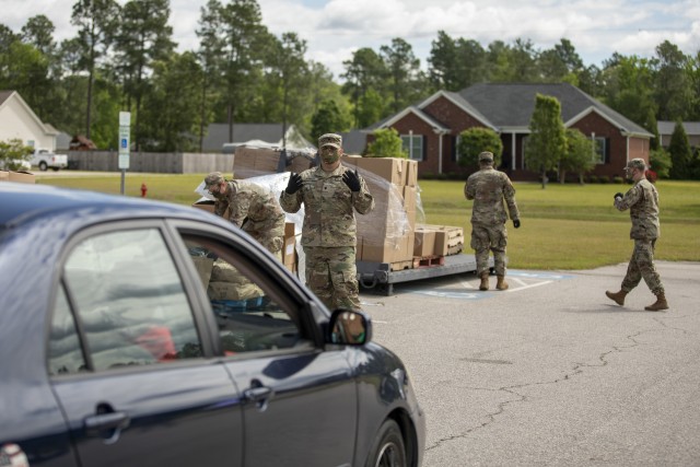 North Carolina National Guard Soldiers assigned to 2-130 Airfield Operations Battalion, 449th Theater Aviation Brigade, load boxes of food into a vehicles while helping Action Pathways Second Harvest Food Bank of Southeast North Carolina distribute food in Raeford, N.C. on May 5, 2020. More than 900 NCNG Soldiers and Airmen have been activated in response to COVID-19 relief efforts to help support NC Emergency Management, N.C. Department of Health and Human Services, and their local communities.