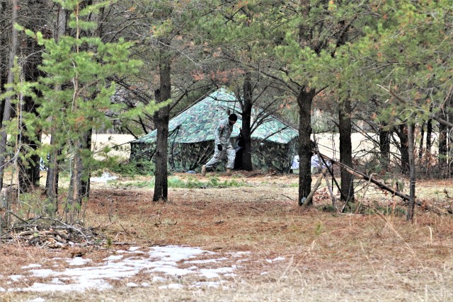 A student in Cold-Weather Operations Course (CWOC) Class 20-05 helps set up a bivouc area March 16, 2020, that includes an Arctic 10-person tent during training on North Post at Fort McCoy, Wis. CWOC students are trained on a variety of...