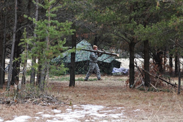 A student in Cold-Weather Operations Course (CWOC) Class 20-05 helps set up a bivouc area March 16, 2020, that includes an Arctic 10-person tent during training on North Post at Fort McCoy, Wis. CWOC students are trained on a variety of...