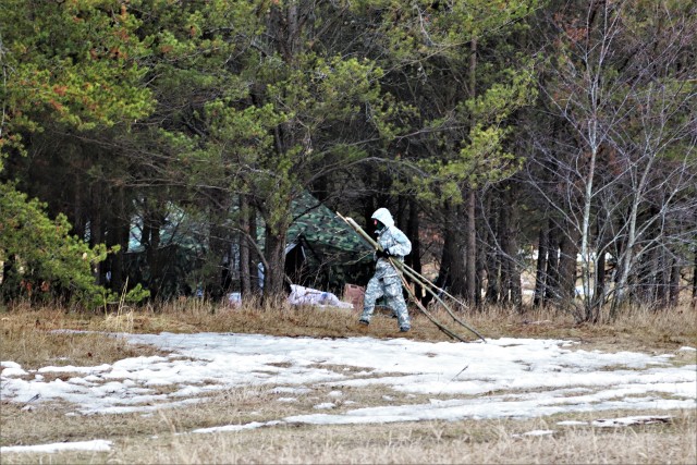 A student in Cold-Weather Operations Course (CWOC) Class 20-05 helps set up a bivouc area March 16, 2020, that includes an Arctic 10-person tent during training on North Post at Fort McCoy, Wis. CWOC students are trained on a variety of...