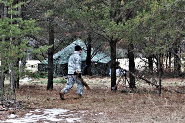 A student in Cold-Weather Operations Course (CWOC) Class 20-05 helps set up a bivouc area March 16, 2020, that includes an Arctic 10-person tent during training on North Post at Fort McCoy, Wis. CWOC students are trained on a variety of...