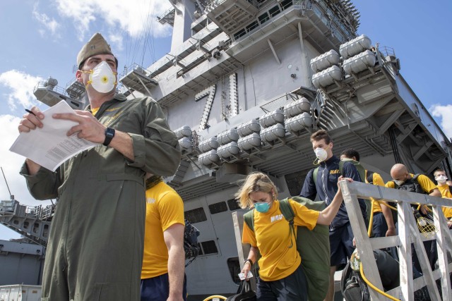 U.S. Sailors assigned to the aircraft carrier USS Theodore Roosevelt (CVN 71) depart the ship to move to off-ship berthing April 10, 2020. Upon arriving in Guam March 27, Theodore Roosevelt established an Emergency Command Center, initiated a...