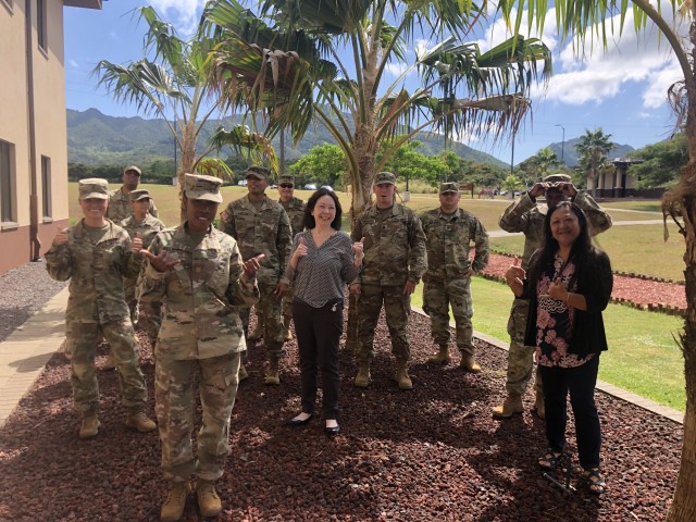 Chief Warrant Officer 2 Meirong Magee (far left) with members of the 500th Military Intelligence Brigade staff at Schofield Barracks, Hawaii. With their hands, they are flashing the shaka Hawaiian greeting, sometimes interpreted as &#34;hang...