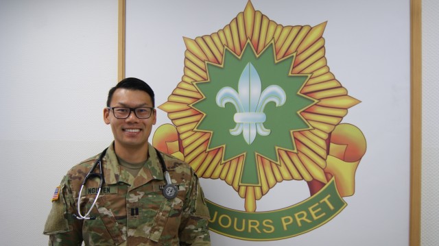 U.S. Army Capt. Trungviet [Joey] Nguyen, regimental nurse, assigned to the 2d Cavalry Regiment, poses in front of the unit crest in Rose Barracks, Germany, May 12, 2020. Nguyen is the only nurse in the 2d Cavalry Regiment. (U.S. Army photo by Maj....