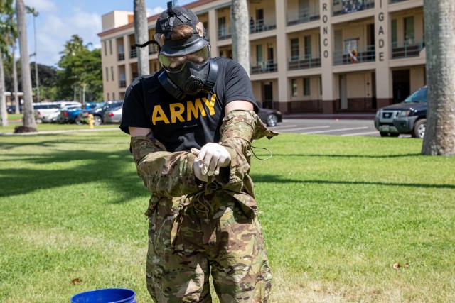 Soldiers at the doffing station remove their gear following a specific procedure to ensure there are no biohazard risks  as part of their clean team training at Schofield Barracks, Hawaii, May 5, 2020. The base cleaning team is a precautionary force established to fight the spread of COVID-19 and protect the health and wellness of Soldiers. (U.S. Army photo by Sgt. Sarah D. Sangster)