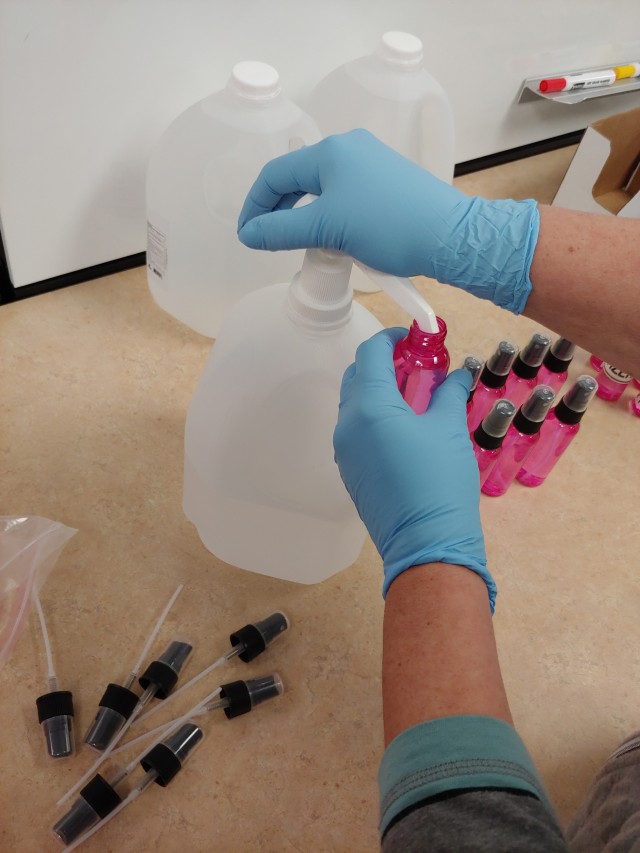 A U.S. Army Aberdeen Test Center (ATC) employee fills bottles of hand sanitizer for distribution to the work force, May 7, 2020. ATC has implemented additional safety guidelines to limit the potential spread of germs as part of the ATC response to COVID-19, allowing the vital test mission to continue safely. Photo illustration courtesy of ATC Technical Imaging Division.