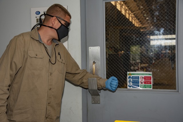 Joe Humphreys, an engineering technician in the Welding Branch, accesses a work area using the “handle-less” door opener created by the U.S. Army Aberdeen Test Center (ATC) Experimental Fabrication Division (EFD) May 7, 2020. The EFD team designed and fabricated several tools to limit the potential spread of germs as part of the ATC response to COVID-19. Photo courtesy of ATC Technical Imaging Division.