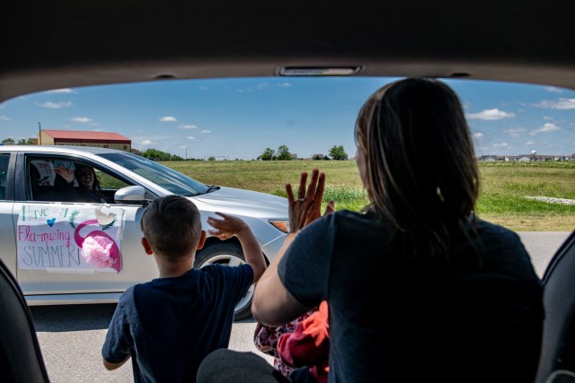 A family waves to Freedom Elementary School staff in their passing car during the parade. Dozens of teachers and Fort Sill first responders participated in the parade May 8, 2020, to show their support for military families.