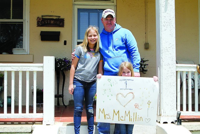Chief Warrant Officer 3 Bobby Eastwood, Capabilities Development and Integration Directorate, and his daughters, Kadence, 11, and Kodi, 6, wait for the parade to pass their house in the White Wolf Manor neighborhood.