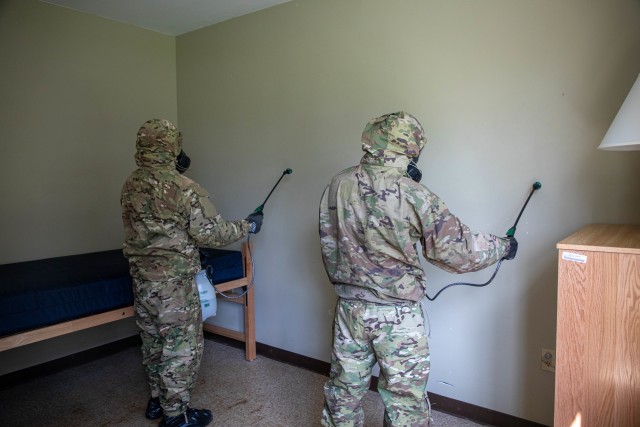 Soldiers simulates spraying a bleach solution as part of their clean team training at Schofield Barracks, Hawaii, May 5, 2020. The base cleaning team is a precautionary force established to fight the spread of COVID-19 and protect the health and wellness of Soldiers. 