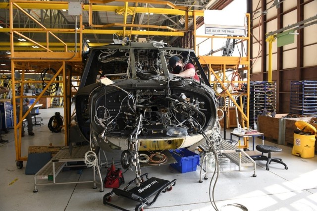 Mary King, aircraft electrician in the avionics/electrical branch at the Corpus Christi Army Depot, Texas, installs the instrument panel wiring harness as part of the assembly and repair of the UH-60L to UH-60V upgrade.