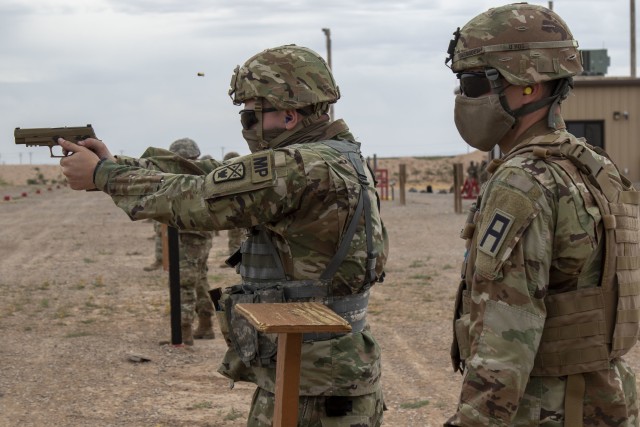 Spc. Henry Jacob, a military police Soldier assigned to 253 Military Police Company, Tennessee National Guard, fires an M17 pistol at McGregor Range Complex, N.M., May 10, 2020.  Sgt. Zachary Yarbrough, right, an Observer Coach/ Trainer assigned to 2-340 Training Support Battalion, 5th Armored Brigade, acts as range safety while 253 MP is training during pre-deployment cohort segregation.  5th Armored Brigade continues to build readiness by providing tough realistic training while working within the constraints of COVID-19.  (U.S. Army photo by Staff Sgt. Timothy Gray, 5th Armored Brigade)