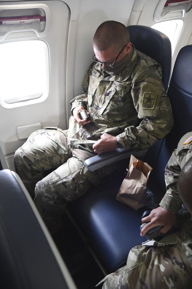 A recently graduated Fort Jackson basic combat trainee buckles his safety belt aboard a chartered flight to Fort Sam Houston, Texas, May 8. Due to the COVID-19 pandemic and a recent stop movement order issued by Secretary of Defense Mark Esper...