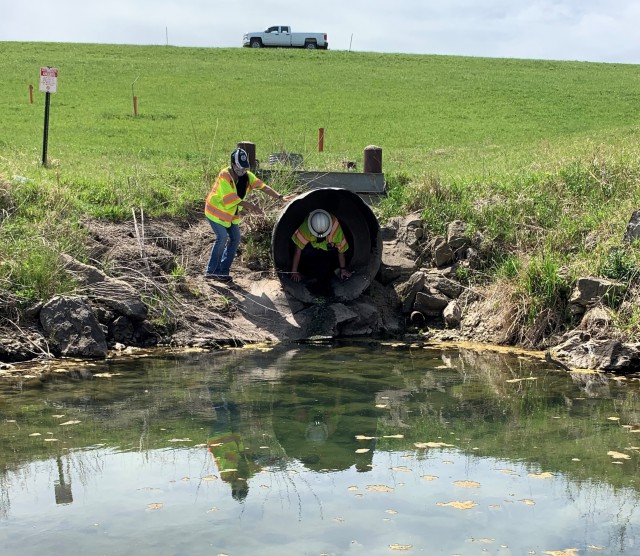 Narturi Narciso, engineer in training, U.S. Army Corps of Engineers, Omaha District, exits a conduit at Salt Creek Site 2, Olive Creek Dam, Neb., after conducting a structural inspection May 1. Kristle Beaudet, dam safety manager, assists with the...
