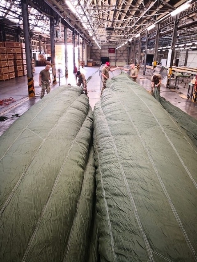 Riggers from the 4th Quartermaster Theater Aerial Delivery Company use an industrial fan to inflate the canopies of a 100 foot diameter G-11 Cargo Parachute System to route the centering lines. (Photo by Chief Warrant Officer 4 Brian Perinon, Japan Support Team, AFSBn-NEA)