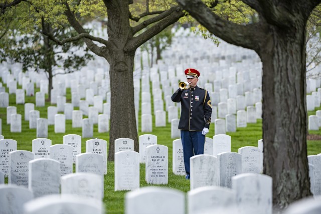 A bugler from the U.S. Army Band, &#34;Pershing&#39;s Own&#34;, plays Taps as part of modified military funeral honors for U.S. Army Retired Command Sgt. Maj. Robert M. Belch in Section 68 of Arlington National Cemetery, Arlington, Virginia, April 14, 2020. 