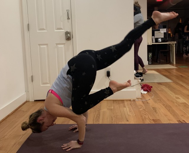 Dorie Chassin, an editor assigned to the U.S. Army Inspector General Agency (USAIGA), and a certified yoga instructor, demonstrates the single-leg crow pose at a yoga studio in Washington, D.C., Feb. 5, 2019. Chassin is working up an online program to lead her USAIGA colleagues in yoga during the coronavirus emergency. (U.S. Army photo courtesy of Dorie Chassin)