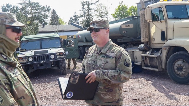 U.S. Army Reserve Spc. Justin Bicknell, right, a truck driver from East Peoria, Illinois, talks with Staff Sgt. Anthony Sohne after arriving with a tanker fuel of fuel at the port in Gydnia, Poland April 30. Bicknell and his fellow Soldiers from the 724th Transportation Company out of Bartonville, Illinois, are deployed to Poland where they have been busy transporting fuel and cargo to base camps throughout the country. (U.S. Army Reserve photo by Master Sgt. Ryan C. Matson, 652nd Regional Support Group)