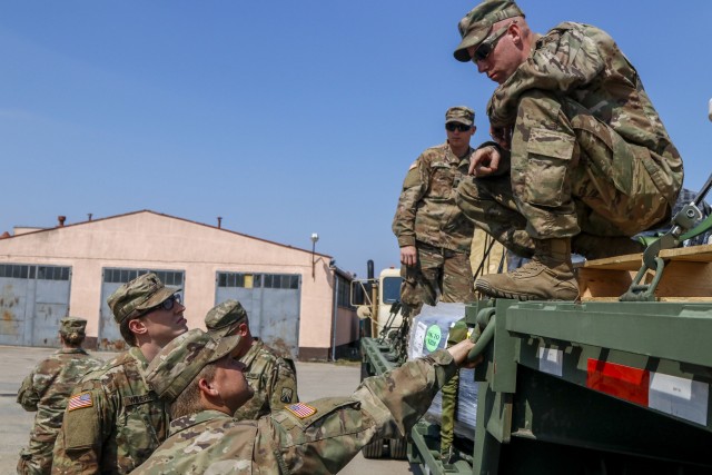 U.S. Army Reserve Staff Sgt. James Lowe, a platoon sergeant and truck driver from Canton, Illinois (on flatbed), talks with Soldiers from his unit, the 724th Transportation Company, after delivering two flatbeds of maintenance supplies from Powidz Air Base to Drawsko Pomorskie Training Area April 28 at DPTA, Poland. Lowe and his fellow Soldiers from the 724th TC out of Bartonville, Illinois, are deployed to Poland where they run fueling and supply missions to base camps throughout the country. (U.S. Army Reserve photo by Master Sgt. Ryan C. Matson, 652nd Regional Support Group)