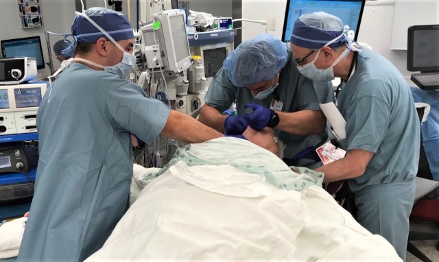 Army Maj. Ryan K. Ransom (left), a registered nurse and officer-in-charge of U.S. Army Medical Command’s Army Military-Civilian Trauma Team Training at Cooper University Hospital, Camden, New Jersey, assists in preparing a patient for surgery