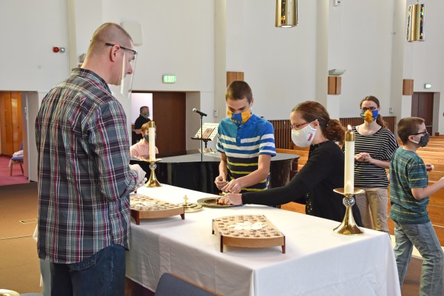 WIESBADEN, Germany - Families and individuals receive the sacrament of communion for the first time in more than 10 weeks May 17 at Hainerberg Chapel. Some social distancing measures were lifted, allowing the sacrament service to resume while parishioners wore masks, washed their hands and entered the chapel one person or family at a time.