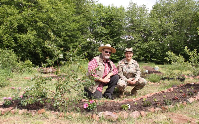 Baumholder Military Community housing residents Harold Schlund and Army Capt. Estela Schlund, 254th Medical Detachment, smile for a picture with the garden they started in the family housing area on Smith Barracks. The community garden is the...