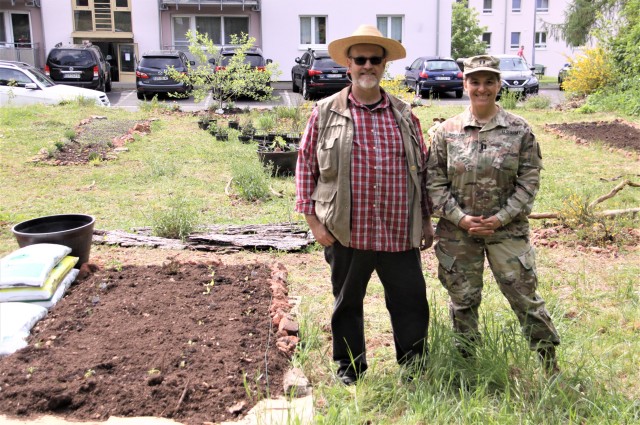 Baumholder Military Community housing residents Harold Schlund and Army Capt. Estela Schlund, 254th Medical Detachment, smile for a picture with the garden they started in the family housing area on Smith Barracks. The community garden is the...