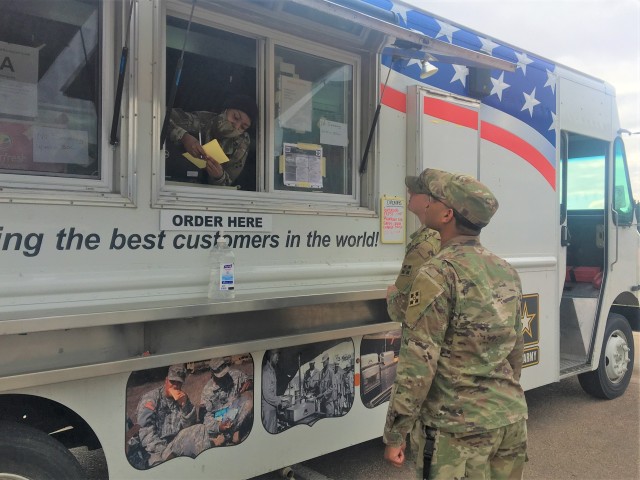 FORT CARSON, Colo. – Spc. Tamiya N. John (left), a culinary specialist assigned to 2nd Battalion, 12th Field Artillery Regiment, 1st Stryker Brigade Combat Team, 4th Infantry Division, takes food orders from Warhorse Soldiers of 2nd Infantry Brigade Combat Team, 4th Inf. Div. from the Outpost Food Truck during its rounds around Fort Carson, Colorado, May 8, 2020. Currently, the Soldiers operating the food truck serves healthy meal choices to Soldiers unable to easily reach Mountain Post Ivy Warrior Restaurants during the COVID-19 pandemic. (U.S. Army photo by Staff Sgt. Scott J. Evans, 4th Infantry Division Public Affairs Office)