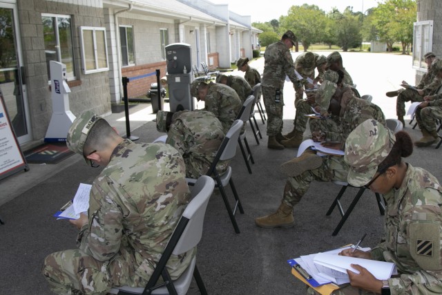 Soldiers arriving by bus from their advanced individual training at Fort Gordon, Ga., fill out initial in-processing paperwork at the Marne Reception Center, Fort Stewart, Ga., May 15, 2020. To maintain the health and safety of incoming personnel...