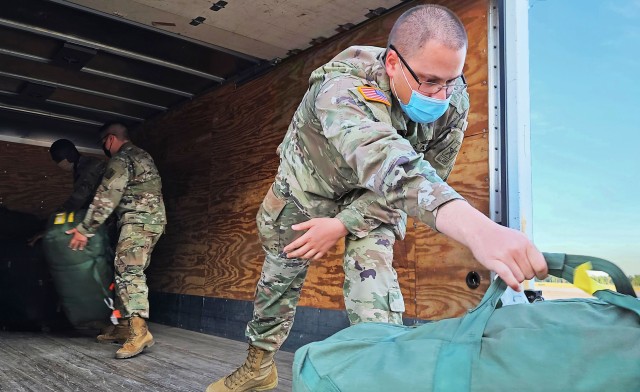 Soldiers fresh out of advanced individual training arriving from Fort Huachuca, Ariz., load their luggage onto a truck just outside the Truscott Air Terminal at Hunter Army Airfield, Ga., May 13, 2020. To maintain the health and safety of incoming...