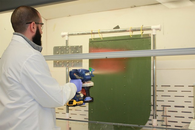 Clear Scientific senior scientist Patrick Reust applies Decon Slurry to a vertical surface in the company’s research laboratory.