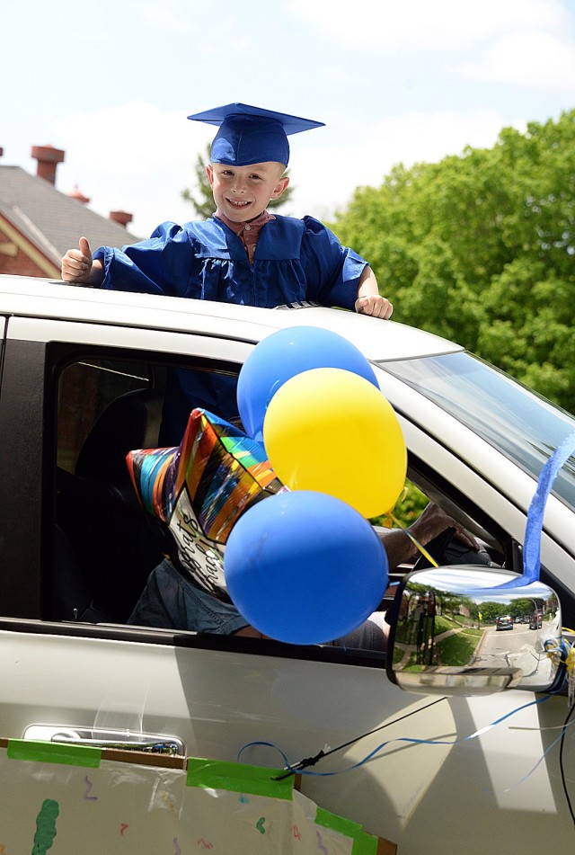 Kindergartner Liam Martin gives a thumbs up as he passes spectators along the graduation parade route May 15 on Grant Avenue. Kindergartners, Patton Junior High School ninth-graders and area high school seniors participated in the parade that...